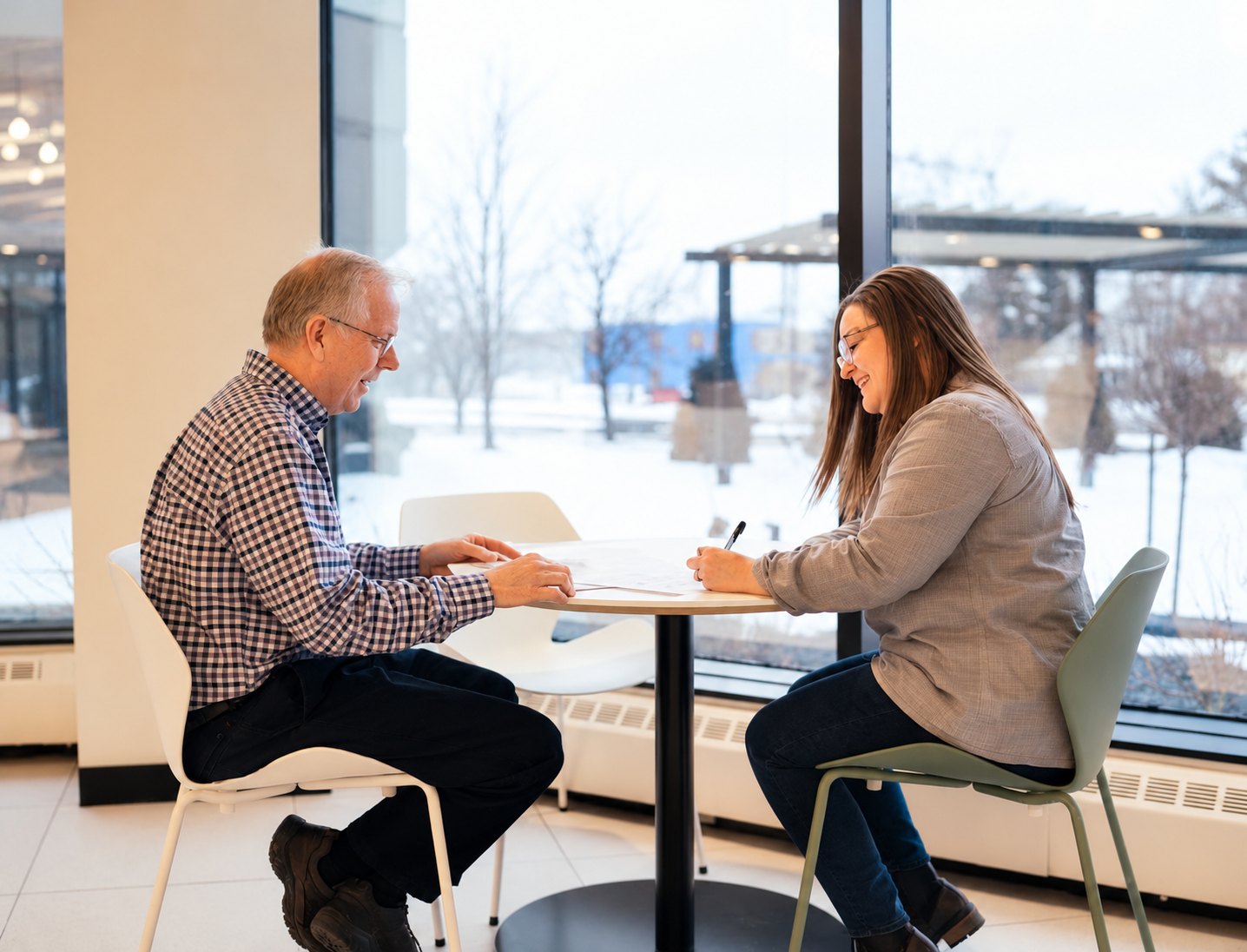 An advisor and a student reviewing a document together at a table